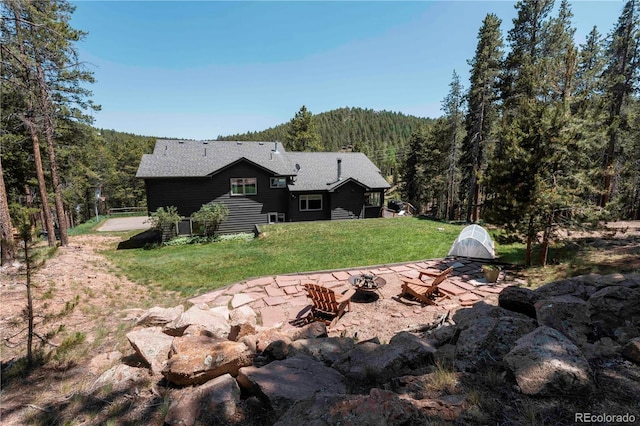 32663 Donna Dr, Conifer, CO 80433 - view of grassy yard with an outdoor fire pit and a forest view