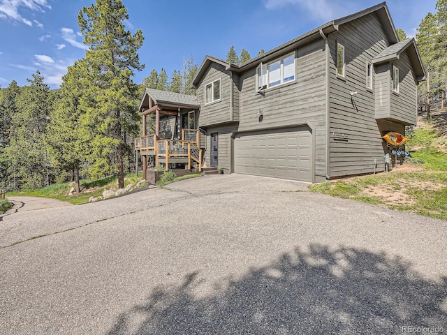 32663 Donna Dr, Conifer, CO 80433 - view of front facade featuring asphalt driveway, an attached garage, and a porch