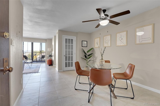 tiled dining space featuring ceiling fan