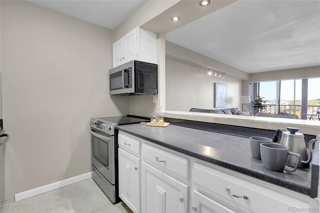 kitchen with white cabinetry, stainless steel appliances, and light tile patterned floors