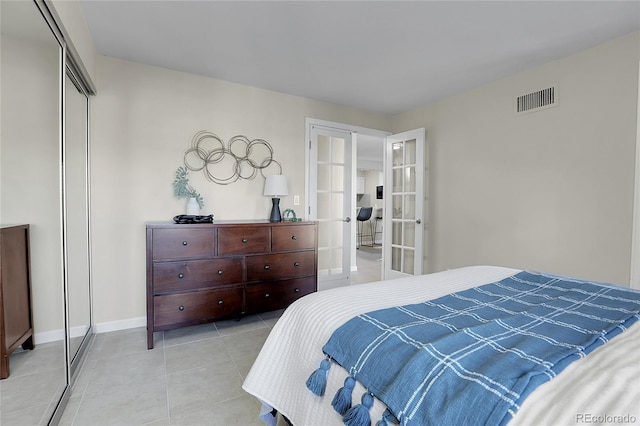 tiled bedroom featuring french doors and a closet