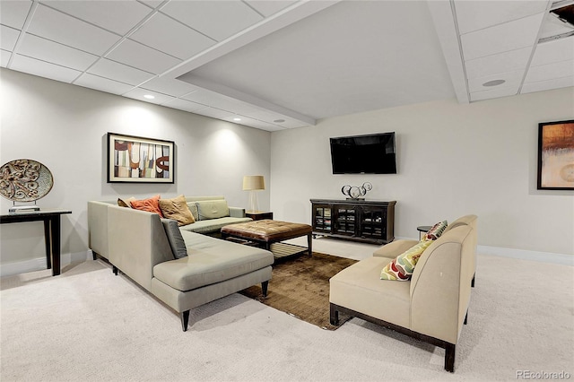 carpeted living room with a drop ceiling