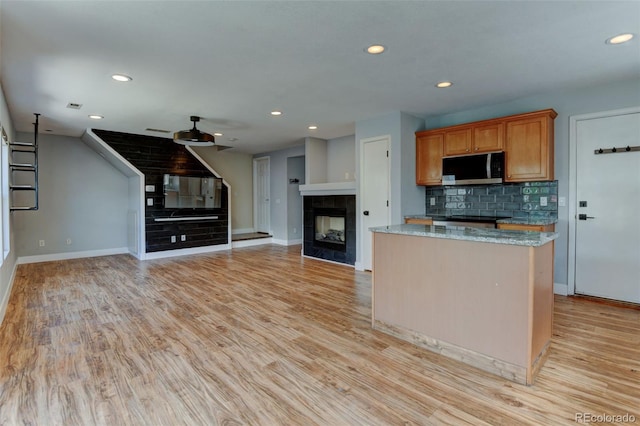 3769 Dahlia St, Denver, CO 80207 - kitchen with stainless steel microwave, baseboards, recessed lighting, a tile fireplace, and tasteful backsplash