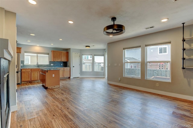 3769 Dahlia St, Denver, CO 80207 - kitchen featuring baseboards, open floor plan, a sink, a center island, and wood finished floors