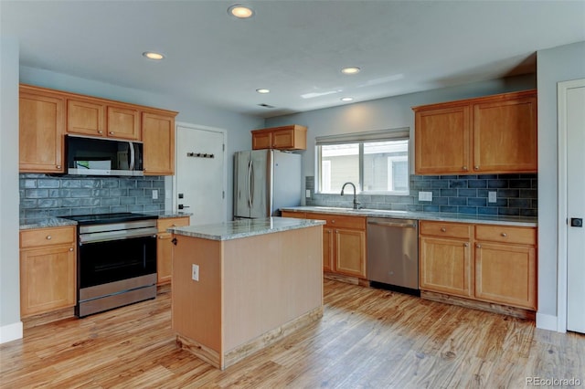 3769 Dahlia St, Denver, CO 80207 - kitchen with appliances with stainless steel finishes, decorative backsplash, light wood finished floors, a sink, and recessed lighting
