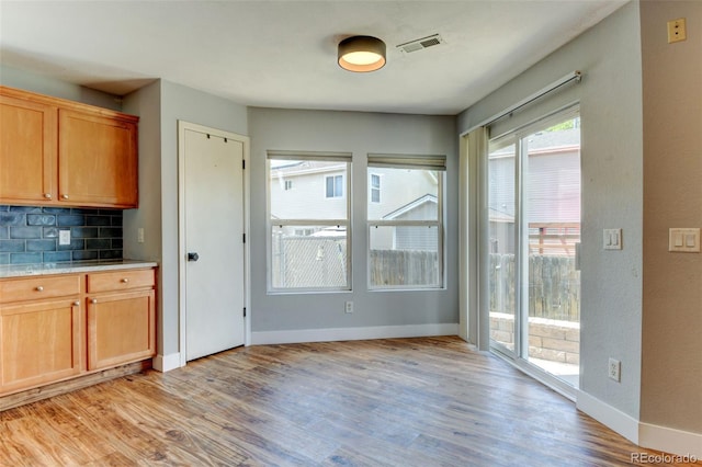 3769 Dahlia St, Denver, CO 80207 - kitchen with light wood-style floors, tasteful backsplash, baseboards, and light countertops