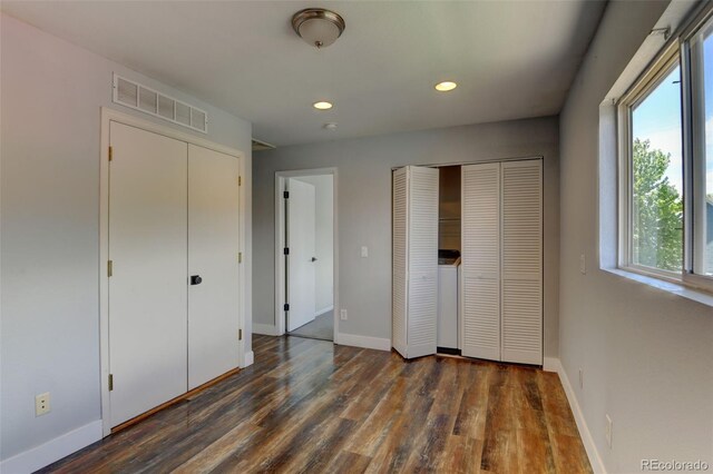 3769 Dahlia St, Denver, CO 80207 - unfurnished bedroom with multiple closets, multiple windows, wood finished floors, and recessed lighting