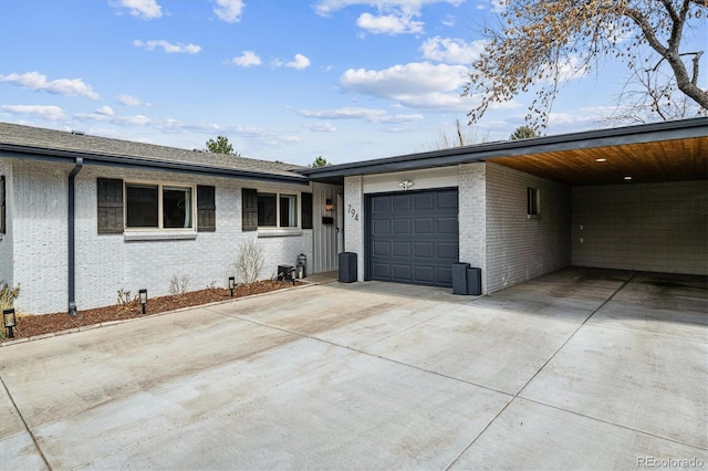 view of front facade featuring concrete driveway, brick siding, and a garage