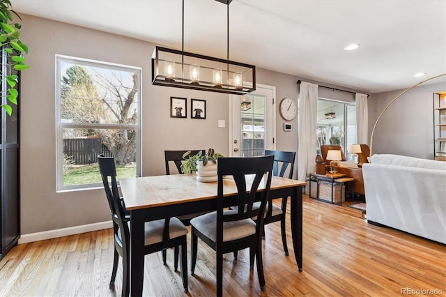 dining room featuring light wood-style flooring, recessed lighting, baseboards, and a healthy amount of sunlight