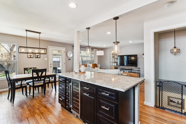 kitchen featuring light wood-style flooring, pendant lighting, light stone countertops, and recessed lighting