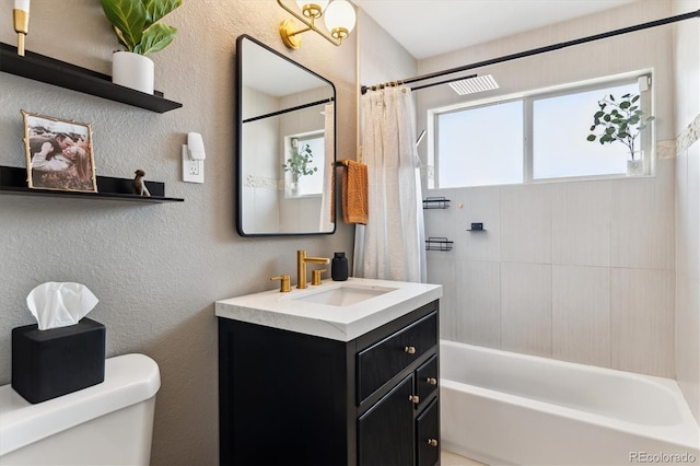 bathroom featuring a textured wall, shower / tub combo, vanity, and toilet