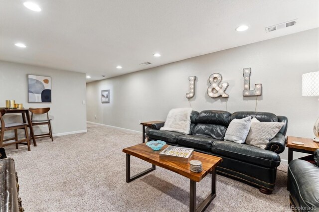 living area featuring light carpet, recessed lighting, and visible vents