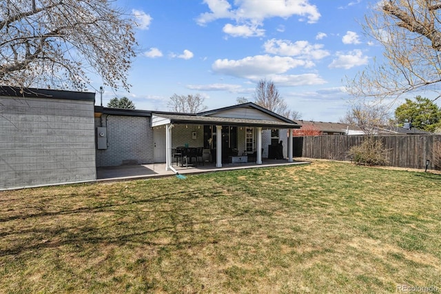 back of property with a yard, a patio, and fence