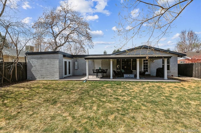 rear view of house featuring french doors, a fenced backyard, a patio area, and a yard