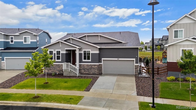 1677 Meagan Way, Erie, CO 80516 - craftsman inspired home with concrete driveway, stone siding, a garage, a residential view, and board and batten siding