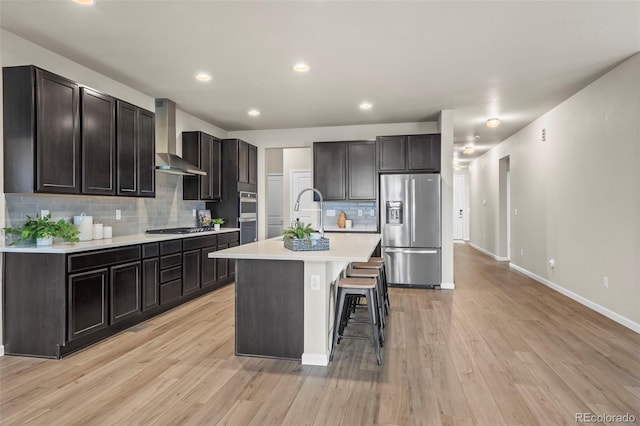 1677 Meagan Way, Erie, CO 80516 - kitchen featuring appliances with stainless steel finishes, wall chimney exhaust hood, backsplash, light countertops, and baseboards