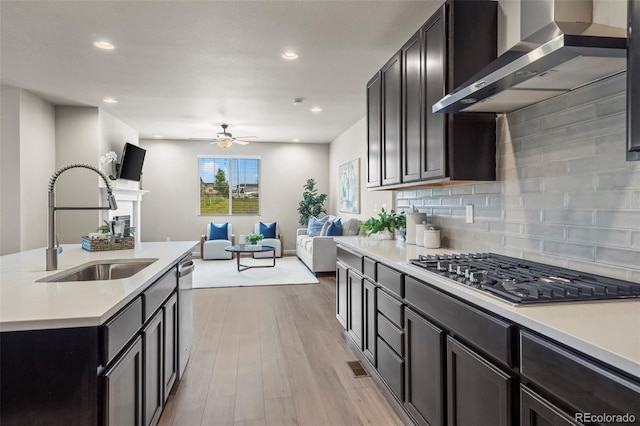 1677 Meagan Way, Erie, CO 80516 - kitchen featuring appliances with stainless steel finishes, wall chimney range hood, a sink, a ceiling fan, and open floor plan