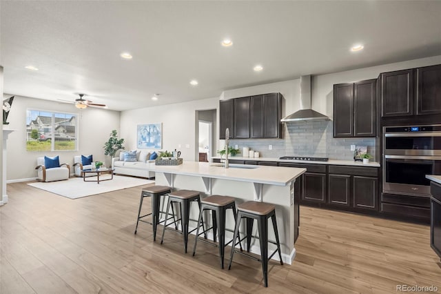 1677 Meagan Way, Erie, CO 80516 - kitchen with wall chimney range hood, a sink, stainless steel double oven, light countertops, and open floor plan