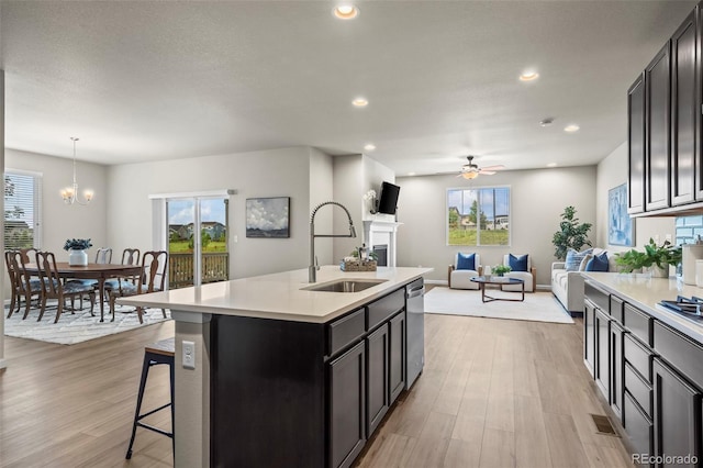 1677 Meagan Way, Erie, CO 80516 - kitchen featuring a sink, light countertops, a ceiling fan, a fireplace, and recessed lighting