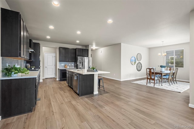 1677 Meagan Way, Erie, CO 80516 - kitchen with light countertops, backsplash, a breakfast bar area, a chandelier, and baseboards