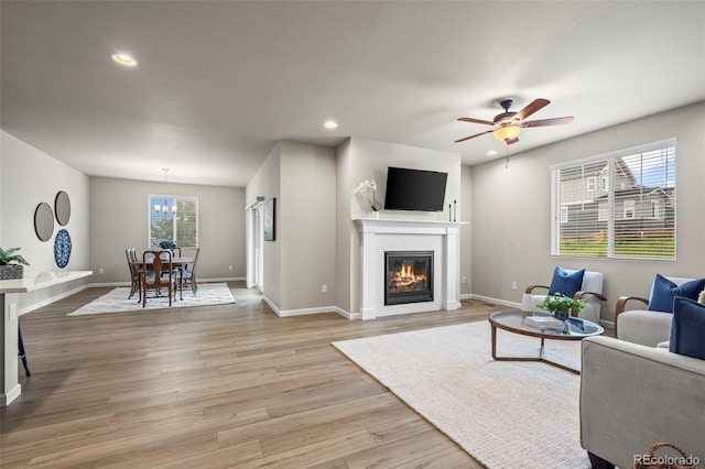 1677 Meagan Way, Erie, CO 80516 - living area with baseboards, a glass covered fireplace, light wood finished floors, recessed lighting, and a ceiling fan