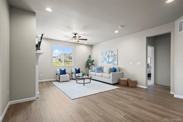 1677 Meagan Way, Erie, CO 80516 - living room featuring a ceiling fan, wood finished floors, recessed lighting, baseboards, and a glass covered fireplace