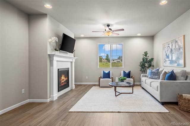 1677 Meagan Way, Erie, CO 80516 - living area with a ceiling fan, wood finished floors, a glass covered fireplace, recessed lighting, and baseboards