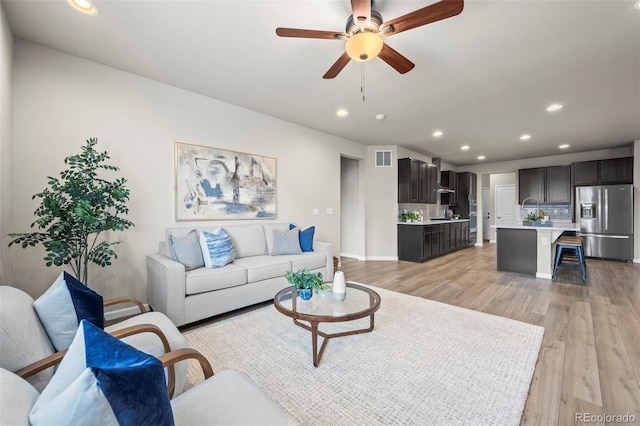 1677 Meagan Way, Erie, CO 80516 - living area featuring recessed lighting, light wood-style floors, ceiling fan, and baseboards