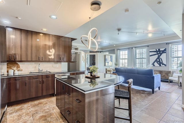 kitchen with sink, a kitchen island, decorative backsplash, and a healthy amount of sunlight