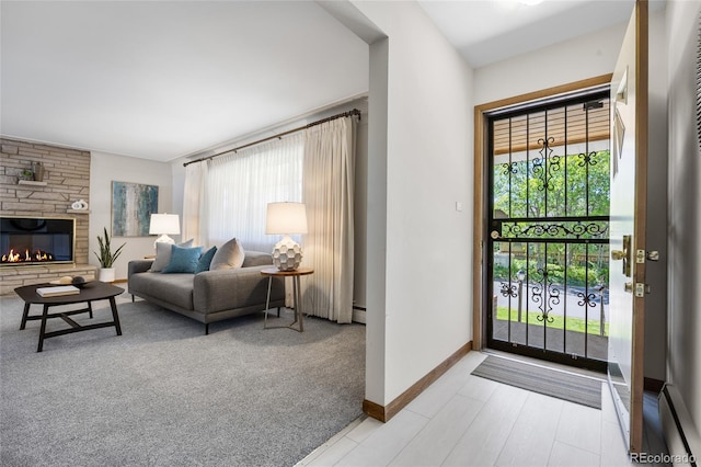 entrance foyer featuring baseboard heating, a fireplace, baseboards, and light carpet