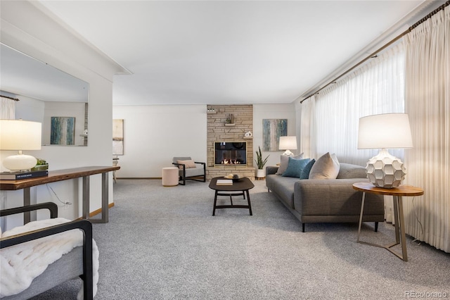 living area with carpet and a stone fireplace
