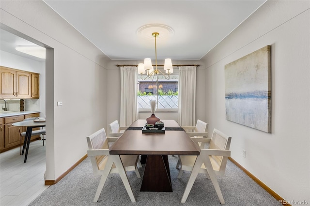 dining space featuring a chandelier and baseboards