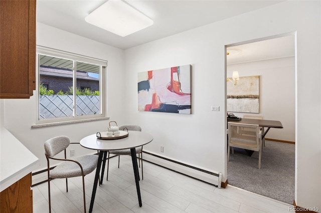 dining area with baseboard heating, baseboards, and light wood finished floors
