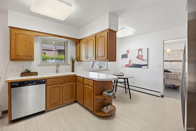 kitchen featuring dishwasher, a sink, brown cabinets, and baseboard heating