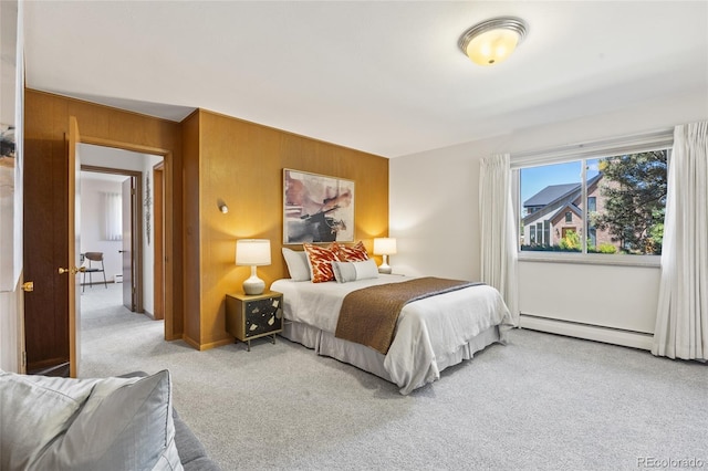 carpeted bedroom with baseboard heating and wooden walls