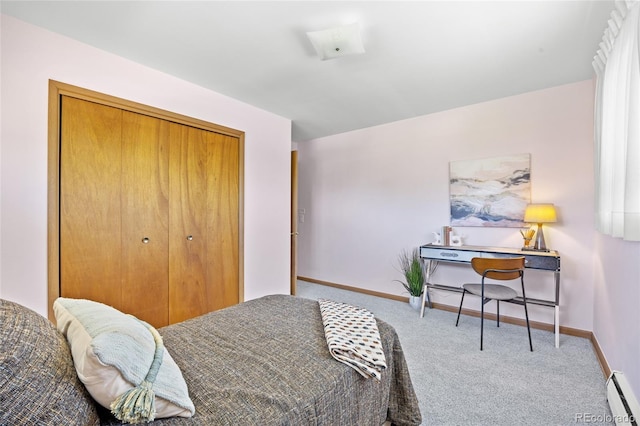 bedroom with baseboard heating, carpet floors, baseboards, and a closet