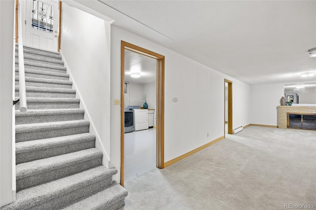 unfurnished living room featuring stairway, separate washer and dryer, carpet flooring, a baseboard heating unit, and baseboards