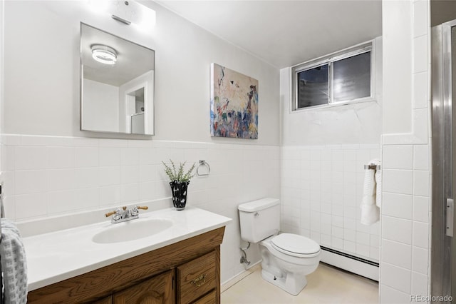 bathroom with baseboard heating, tile walls, toilet, vanity, and a wainscoted wall