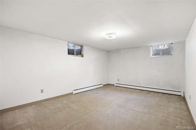basement with a baseboard radiator, baseboard heating, carpet flooring, and baseboards