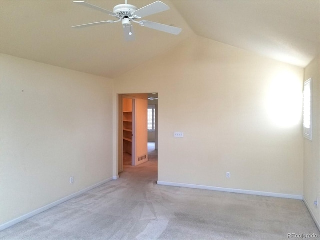 spare room featuring light carpet, ceiling fan, and lofted ceiling