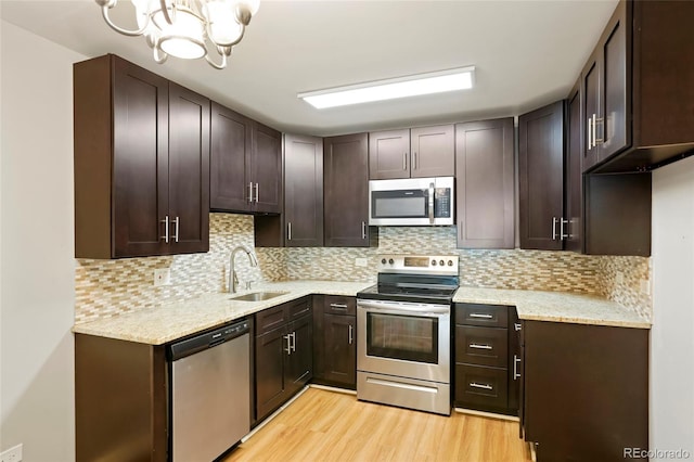 kitchen with light wood-type flooring, sink, dark brown cabinets, and appliances with stainless steel finishes