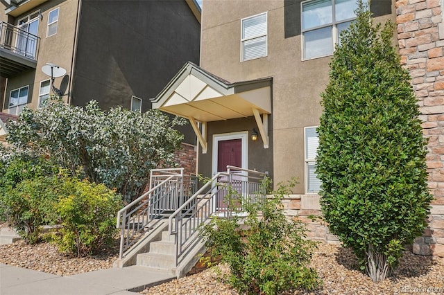 view of exterior entry with a balcony