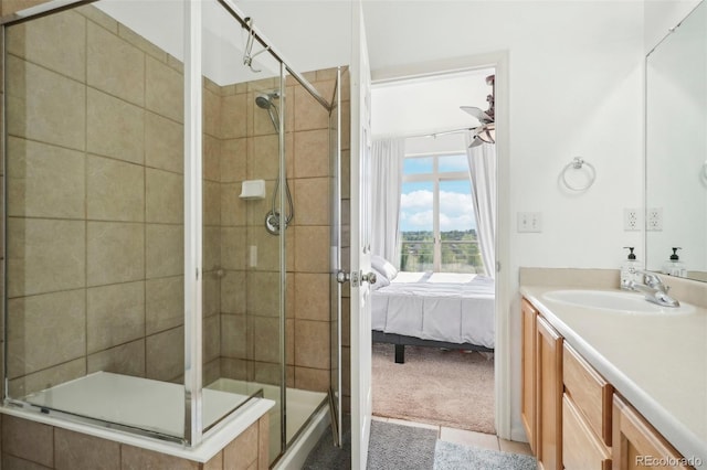 bathroom featuring vanity, a shower with shower door, tile patterned flooring, and ceiling fan