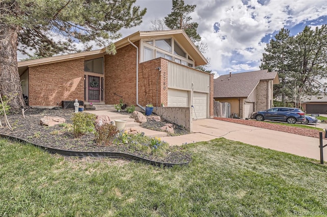 view of side of home with concrete driveway, brick siding, a garage, and a lawn