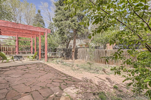 view of yard featuring a fire pit, a patio area, a pergola, and a fenced backyard