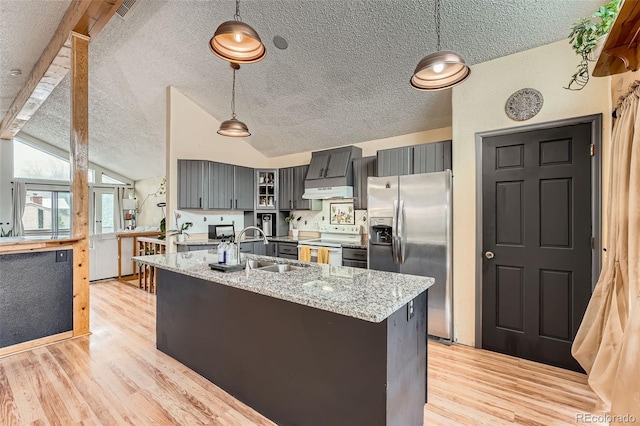 kitchen with a textured ceiling, white range with electric stovetop, light wood finished floors, a sink, and stainless steel fridge