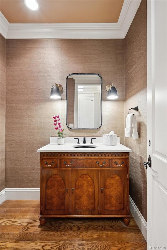 bathroom with baseboards, ornamental molding, wood finished floors, and vanity