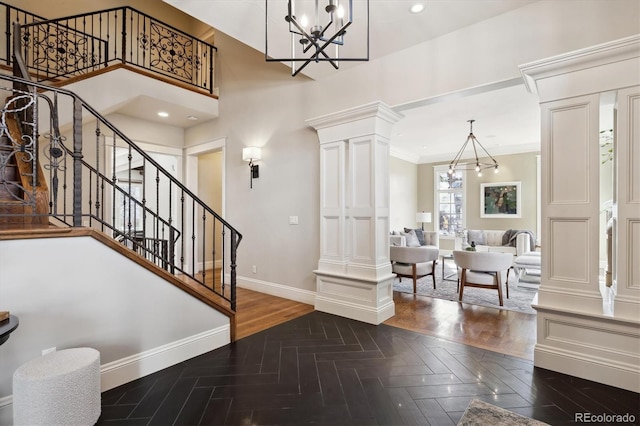 foyer entrance with recessed lighting, baseboards, ornate columns, and an inviting chandelier