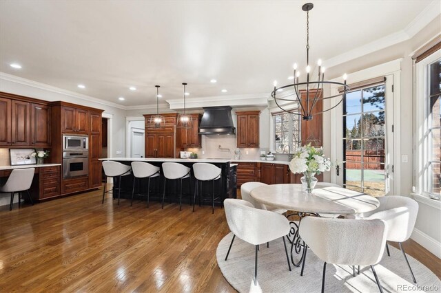 dining room with a chandelier, recessed lighting, dark wood-style flooring, baseboards, and ornamental molding