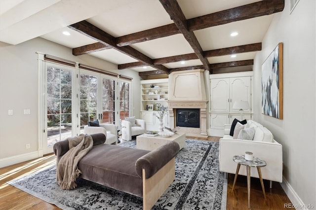 living room featuring beamed ceiling, coffered ceiling, wood finished floors, and baseboards